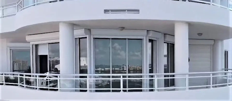 Roll-down screens on a curved high-rise balcony with panoramic Sarasota Bay views