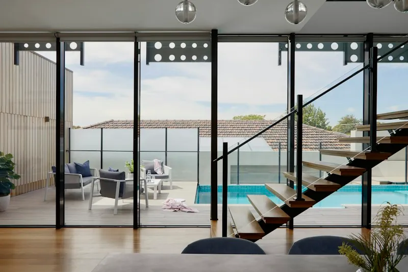 Indoor seating area looking through glass doors to a pool lanai